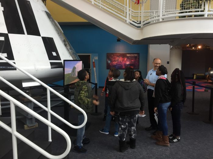 STEM Coach demonstrating an exhibit to kids